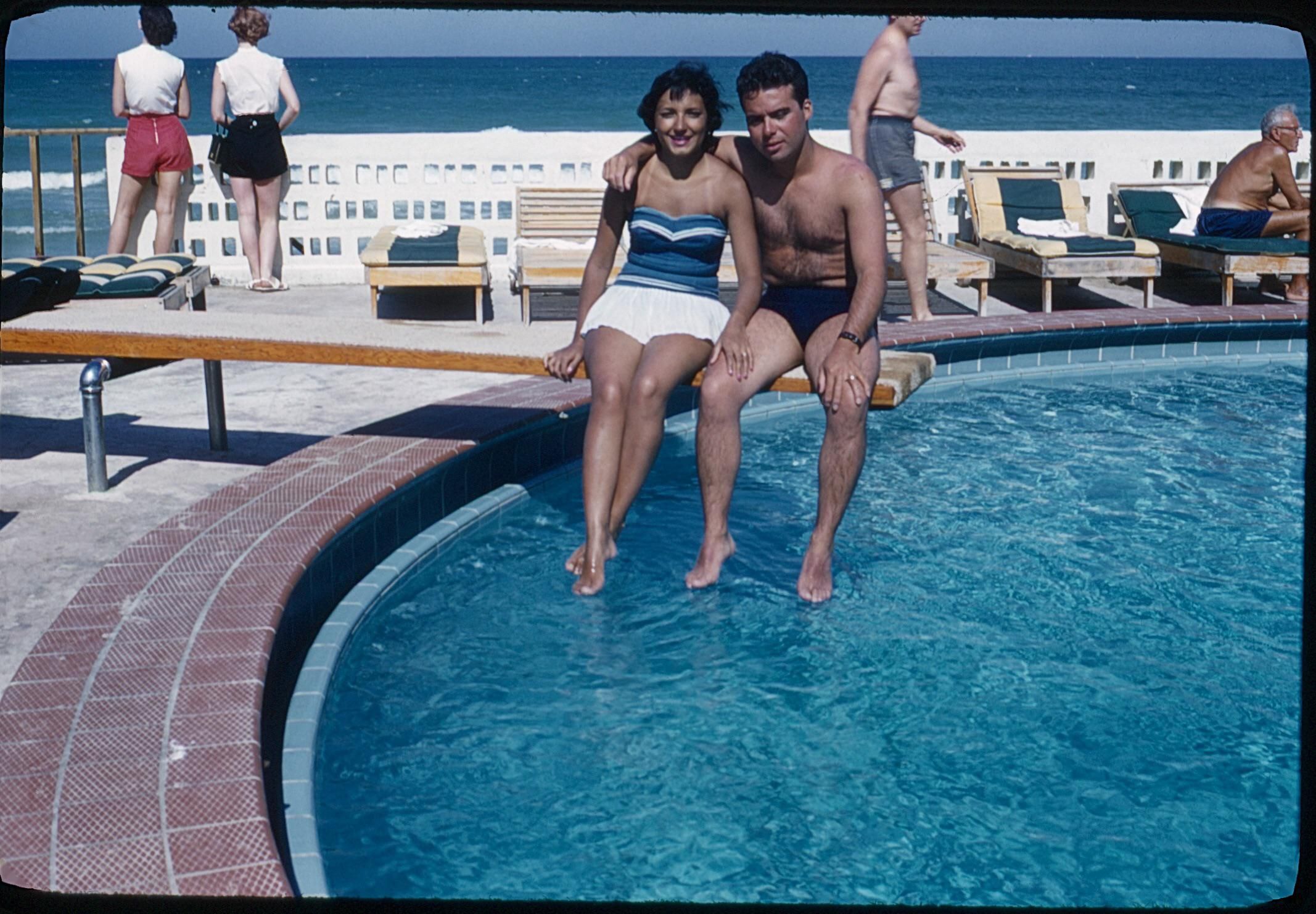 a couple vacationing in florida sitting on a diving board