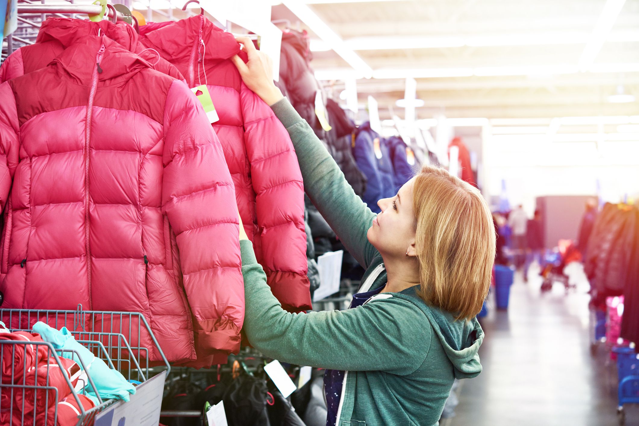 Woman chooses a winter jacket in the store