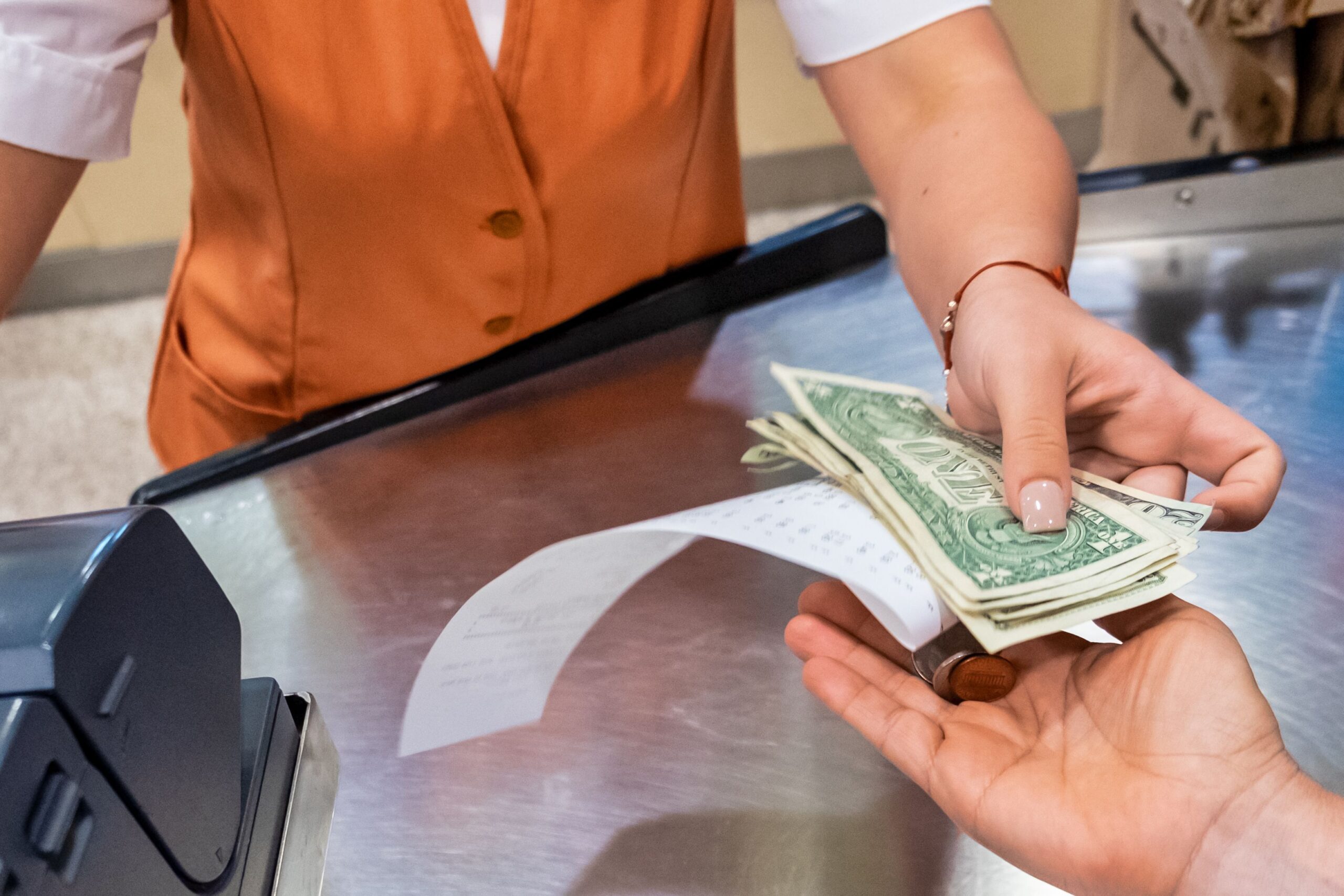 Supermarket cashier giving money back and receipt to customer