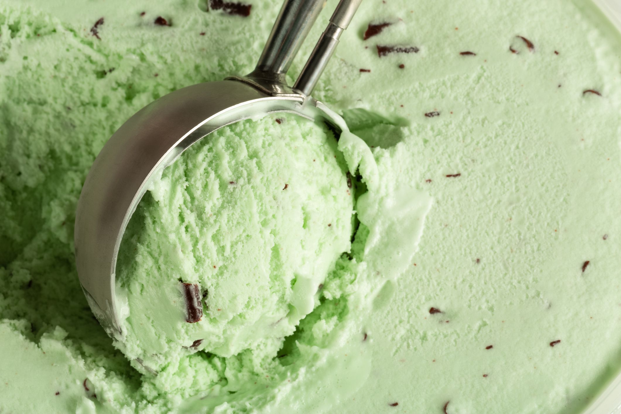 Mint choc chip ice cream being balled up by a mechanical scoop