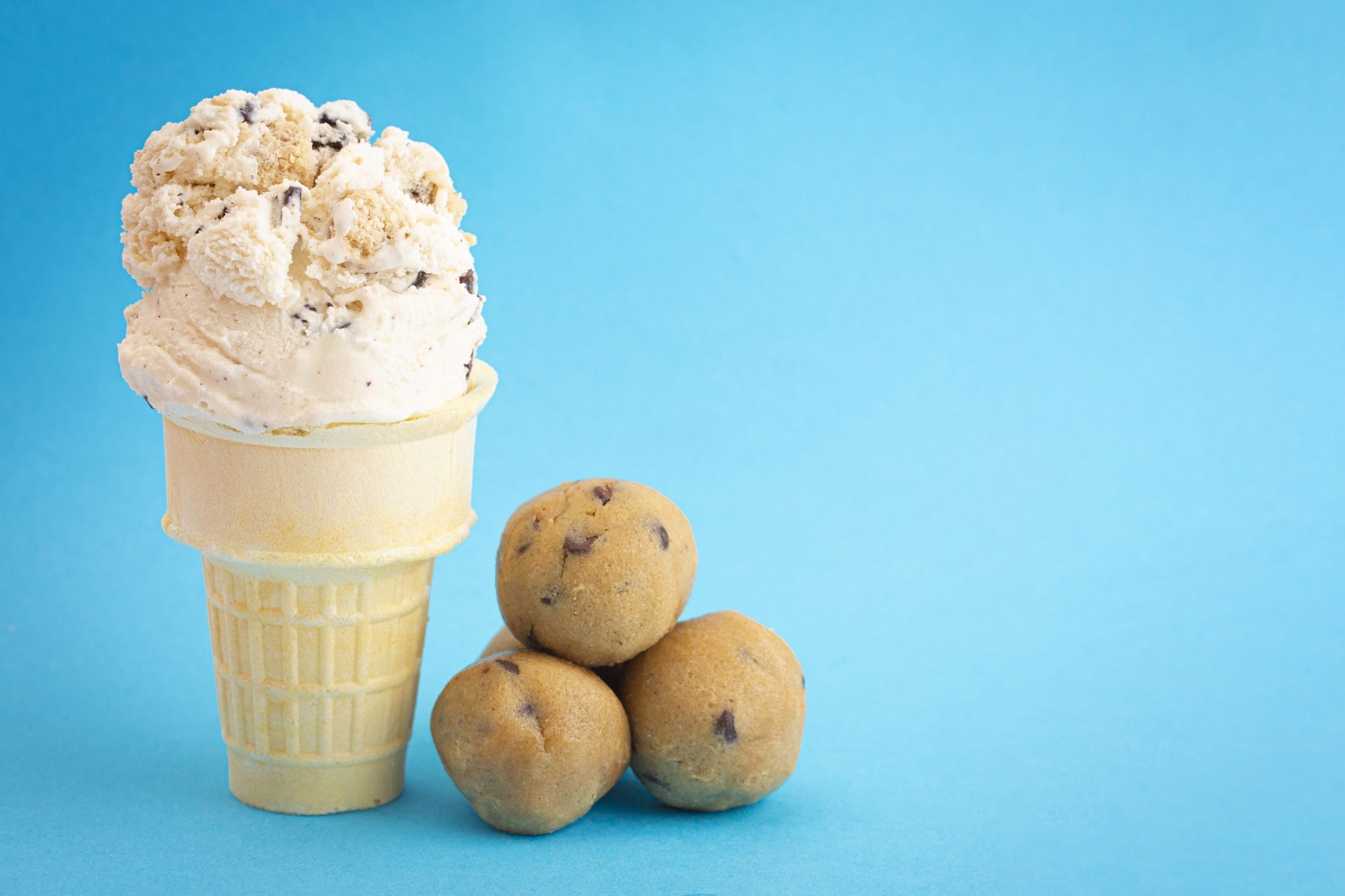 Chocolate Chip Cookie Dough Ice Cream Cone Isolated on a Blue Background