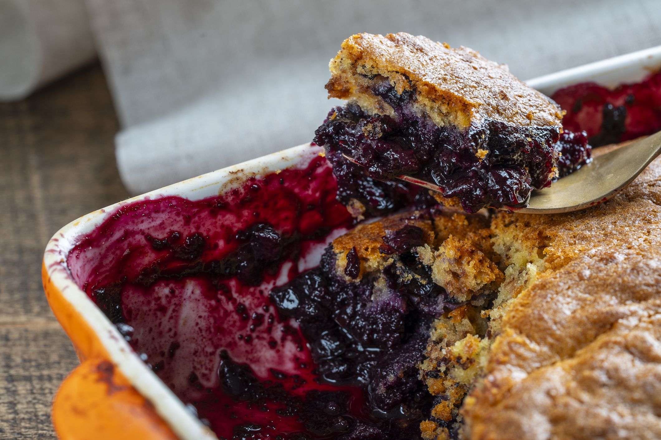 Fresh baked blueberry cobbler in a baking dish with fork. Homemade berry cobbler, close up