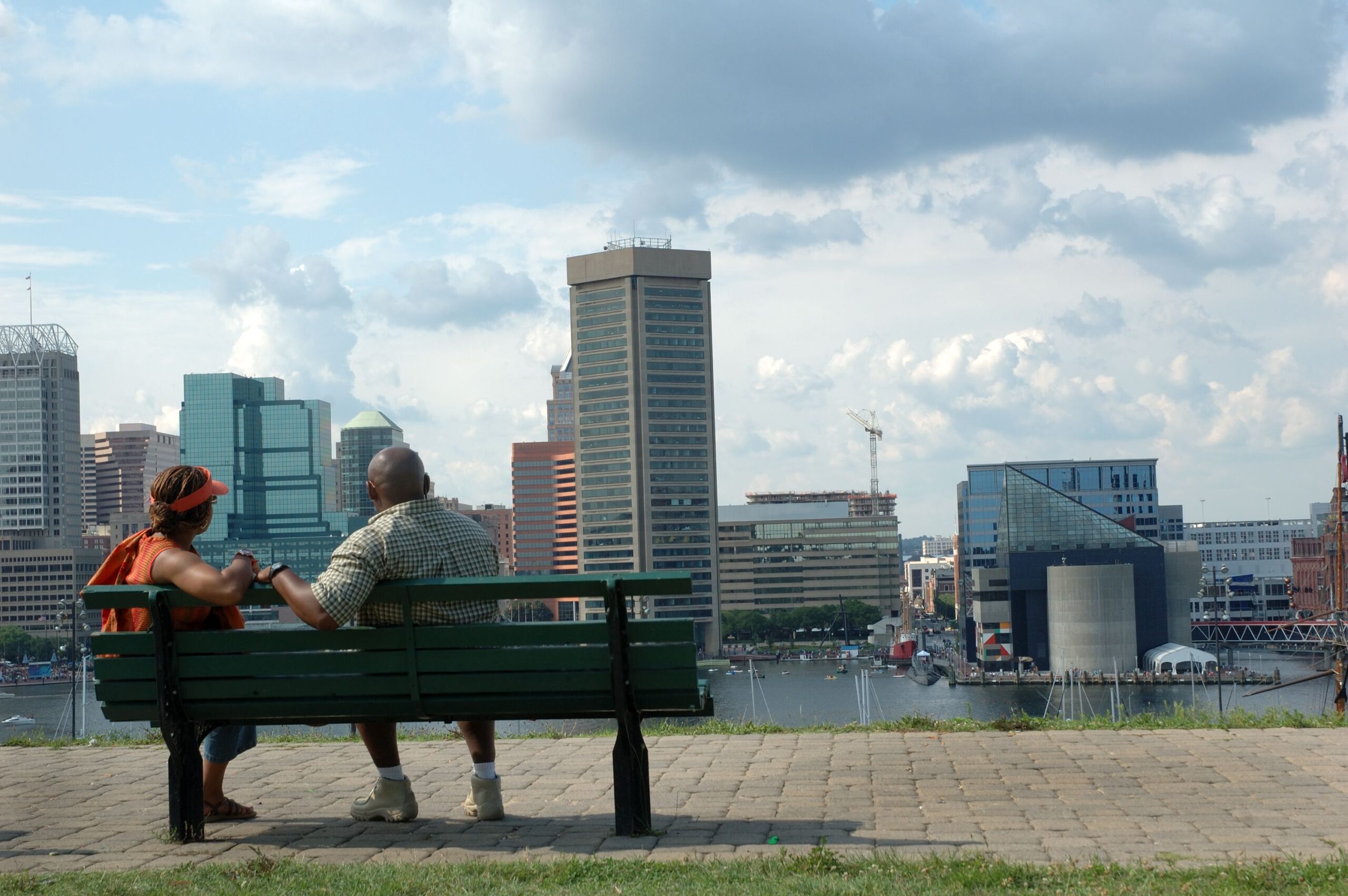 Middle-aged African-American couple look at the Baltimore harbor from the top of Federal Hill. The World Trade Center and National Aquarium can be seen on other side of harbor.