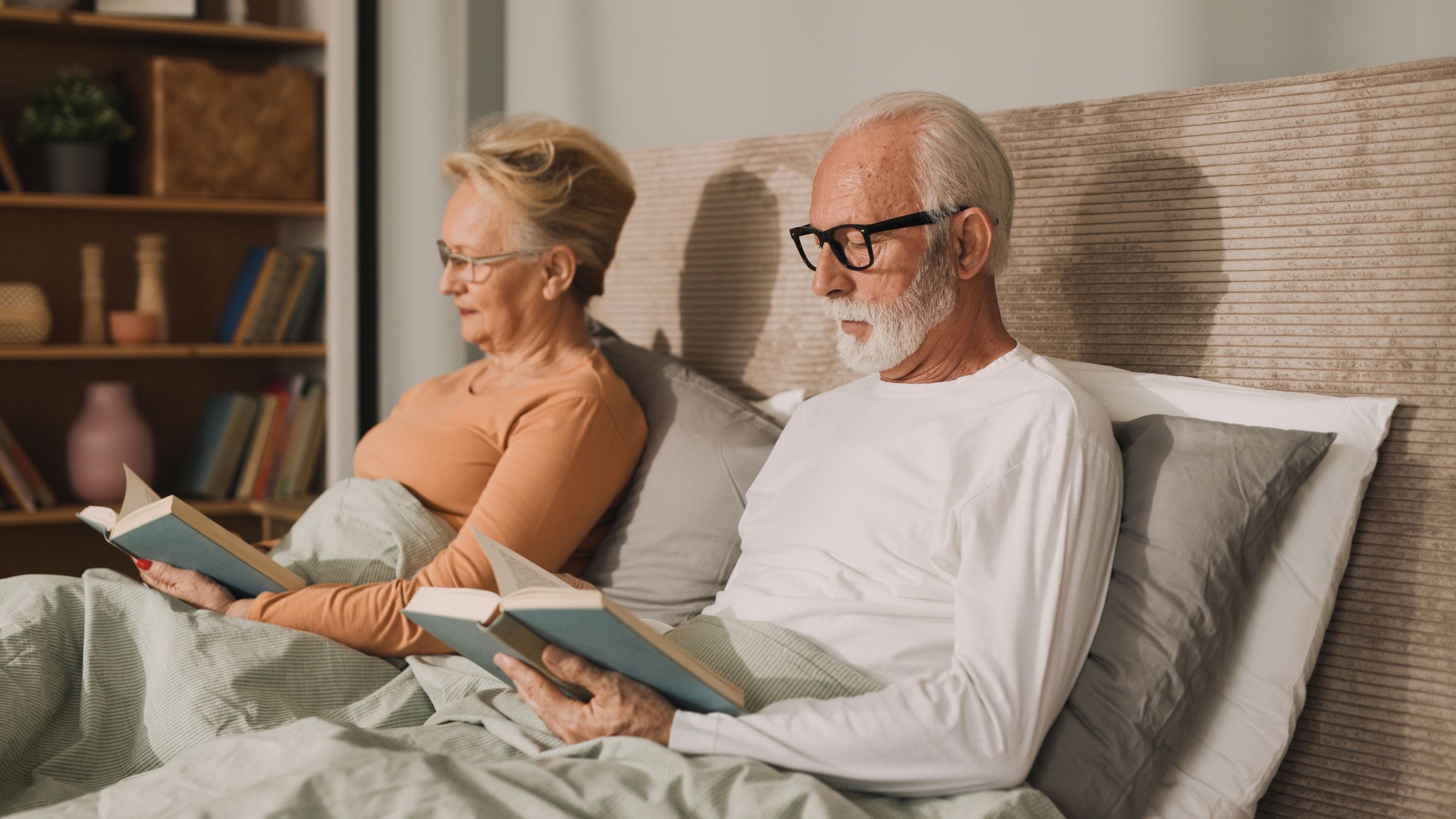 Senior couple reading books in bed