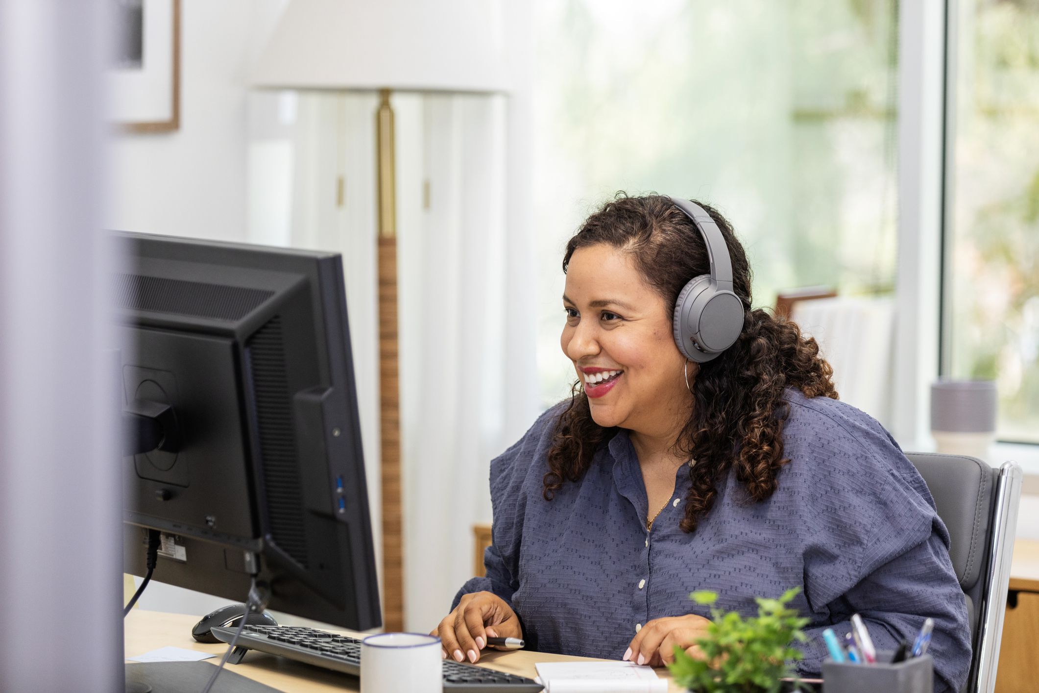 Using her desktop in her home office, the businesswoman is happy to meet with her client through a video call.