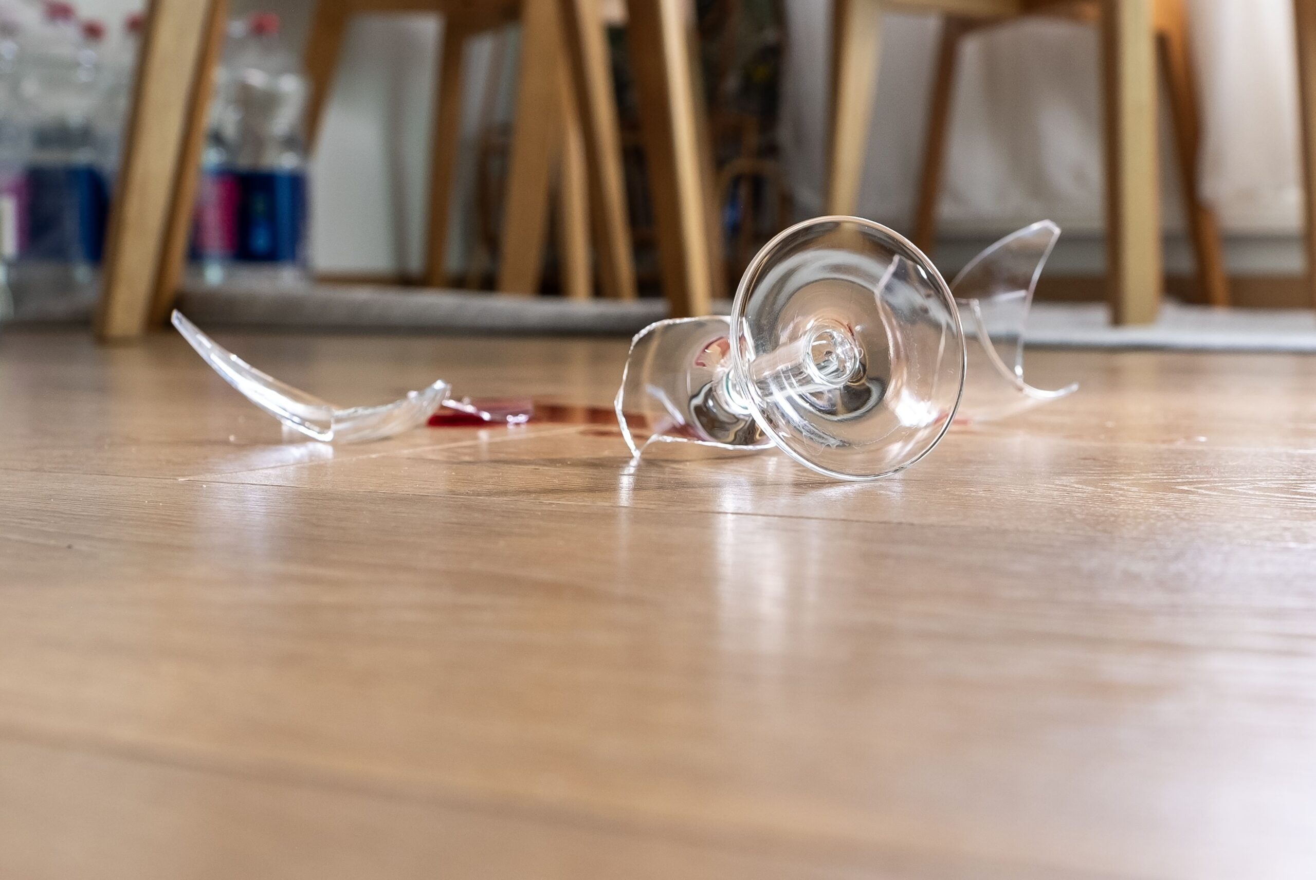 Glass from a broken glass on the floor, a stain from red wine.