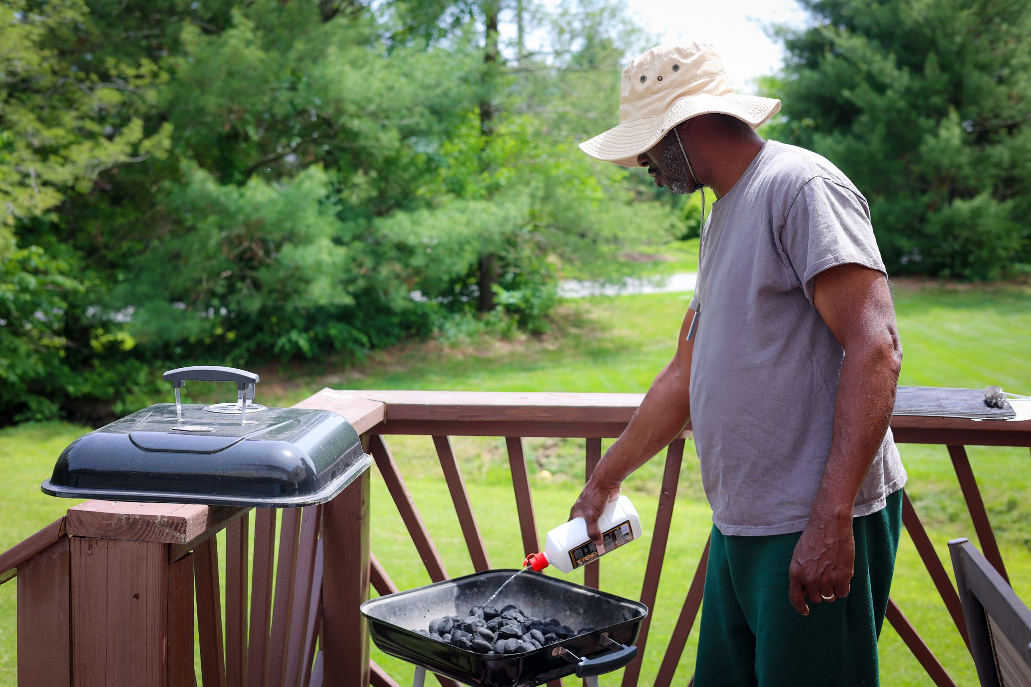 A Portrait Of A Black Man Grilling On A Charcoal Grill
