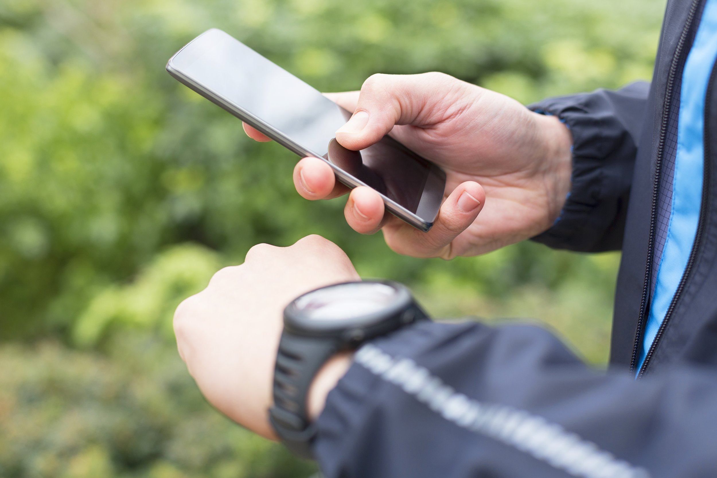 close up of man with mobile phone connected to a smart watch