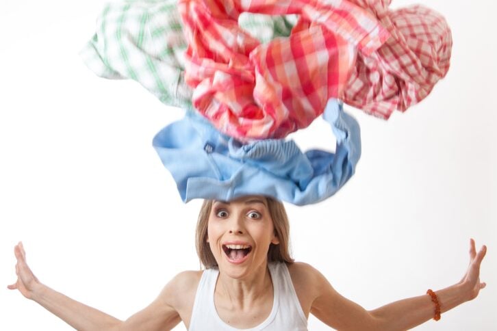 woman throws a pile of clothes
