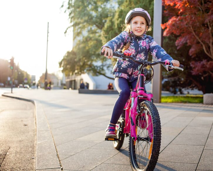 young girl enjoying riding bicycle in a city