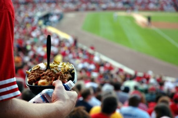 sports fan having nachos at a stadium during baseball game