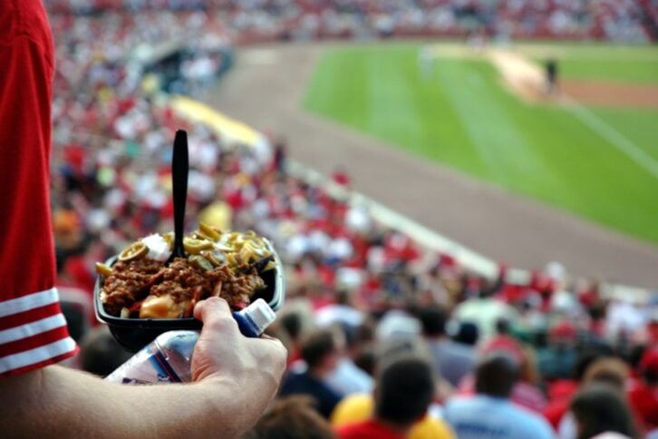 sports fan having nachos at a stadium during baseball game