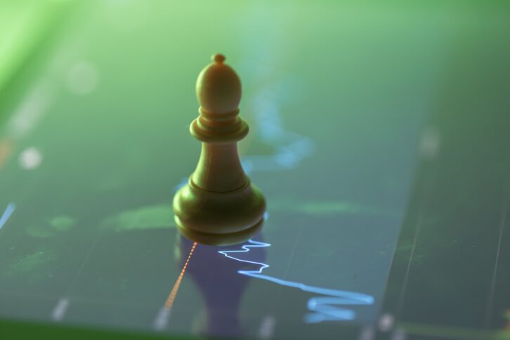 chess on the screen with stock chart