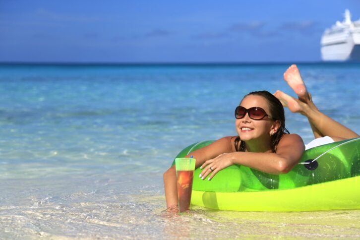 woman enjoying a drink on the beach