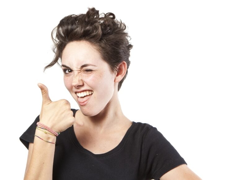 woman with thumbs up gesture saying 'yeah!'