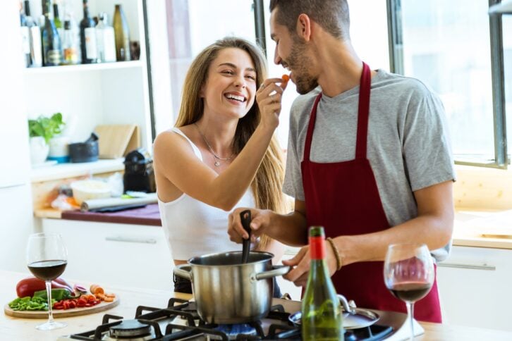 happy young couple cooking together in the kitchen at home