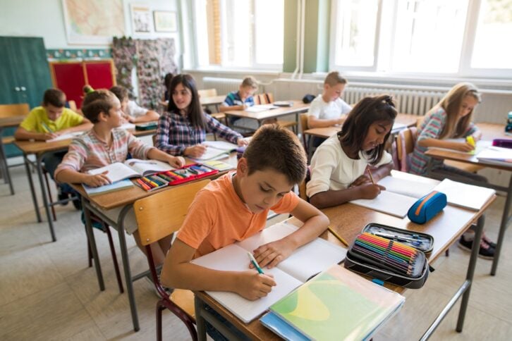 group of school children studying in the classroom