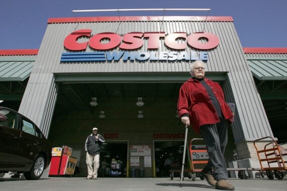 Costco customers walk in front of a Costco Warehouse