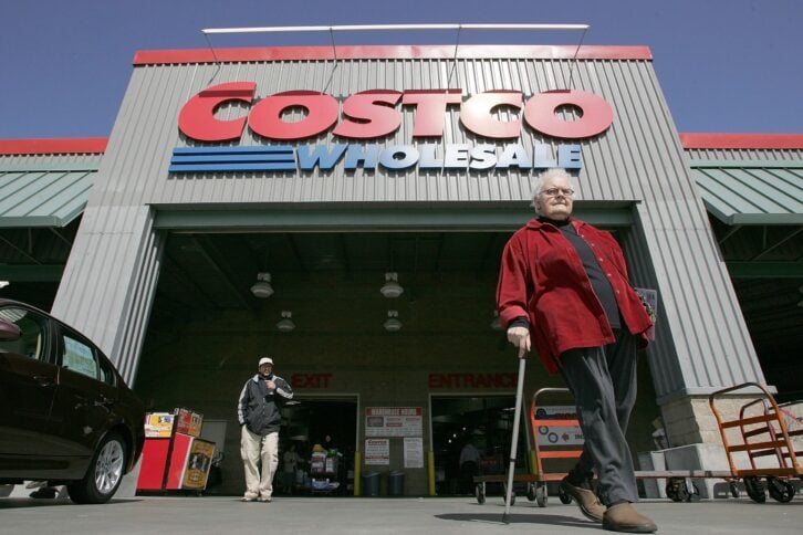 Costco customers walk in front of a Costco Warehouse