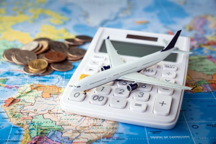 Model airplane on a map with coins and calculator