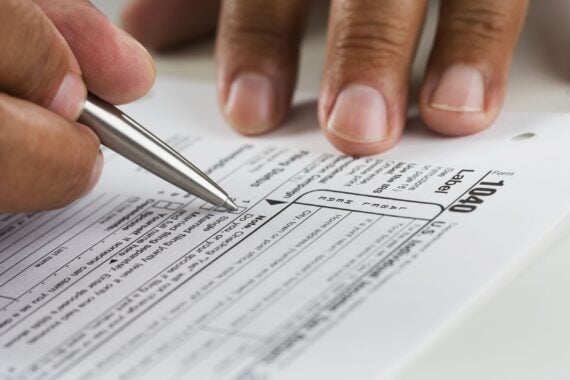 close up of hands filling in tax form