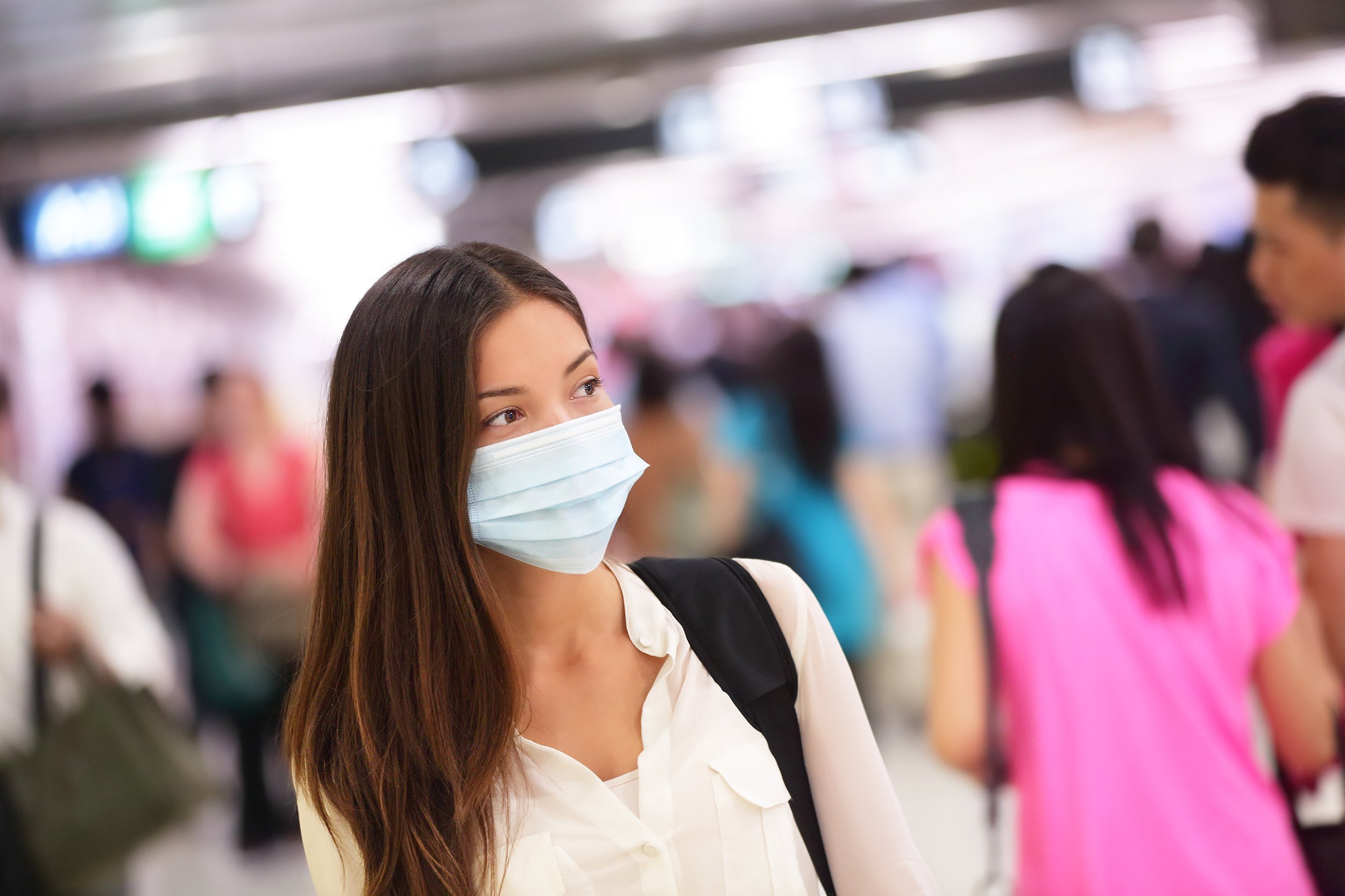 woman wearing protective mask against transmissible infectious diseases in public area