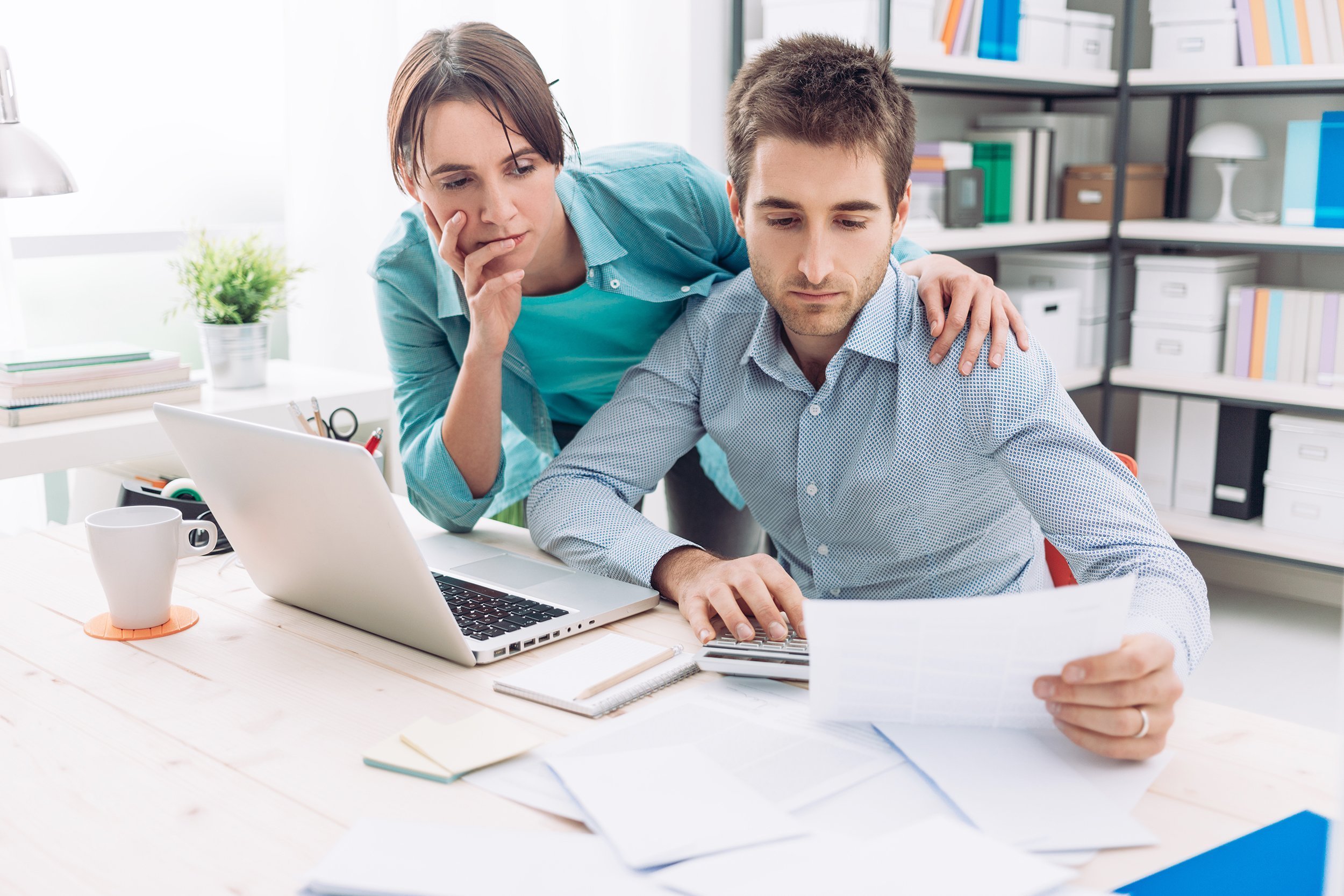 couple at home checking expensive bills at desk