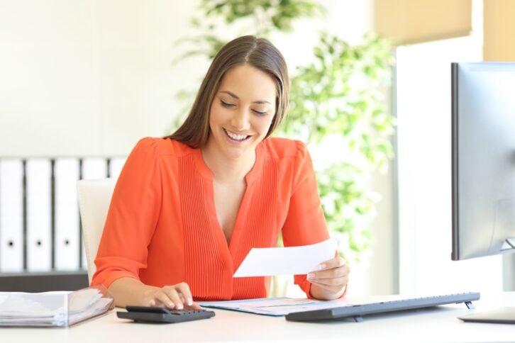 businesswoman doing accounting and calculating with a calculator in a desktop at office