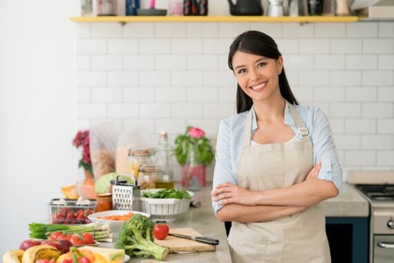 Woman wearing an apron and preparing meals in the kitchen