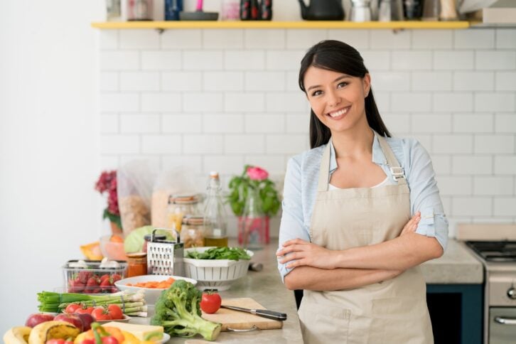 Woman wearing an apron and preparing meals in the kitchen