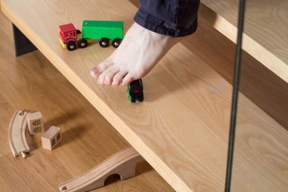 foot about to step on toy on the stairs