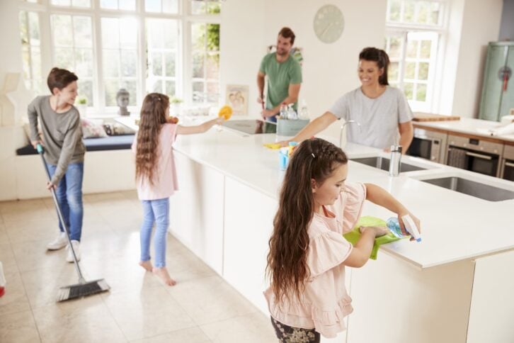 children helping parents with household chores in kitchen