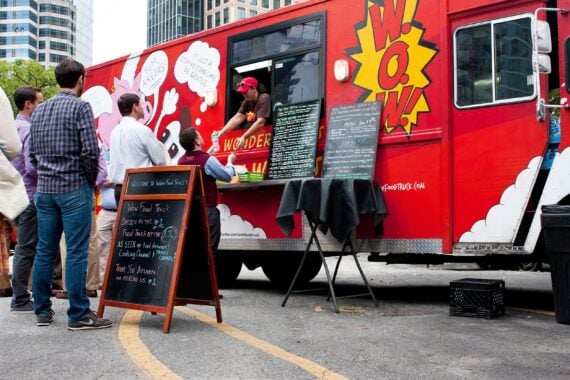 customers wait in line to order meals from a popular food truck during their lunch hour