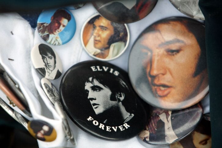 Elvis Presley buttons are seen on a fan's shirt prior to a candlelight vigil at Graceland marking the 25th anniversary of Presley's death during Elvis Week August 15, 2002 in Memphis, Tennessee