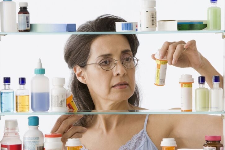hispanic woman taking medication in bathroom