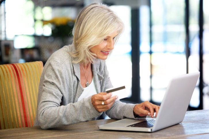 senior woman with laptop computer and credit card