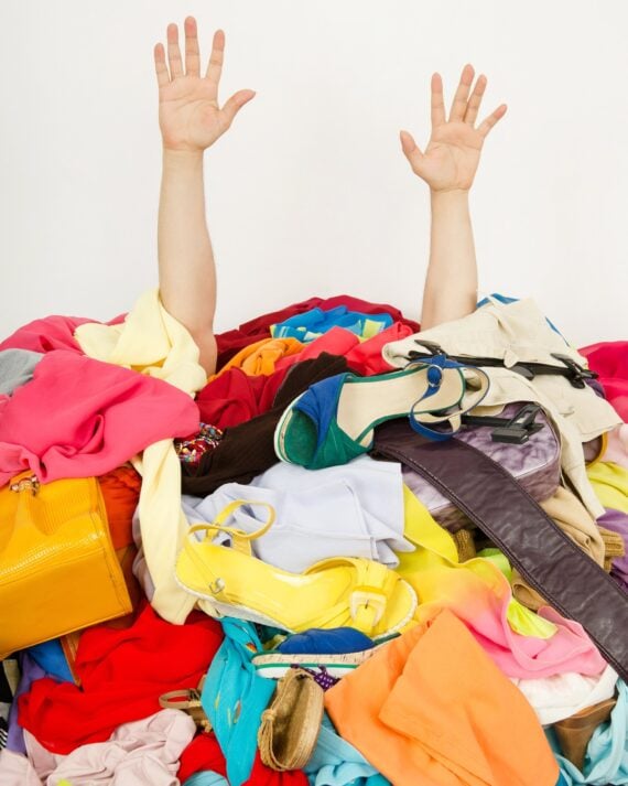hands reaching out from a big pile of clothes and accessories