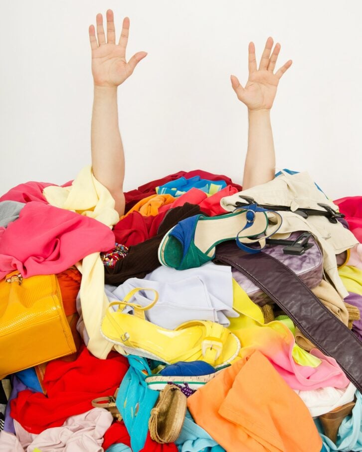 hands reaching out from a big pile of clothes and accessories