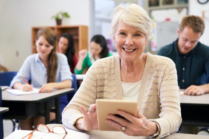 senior woman using tablet computer at adult education class