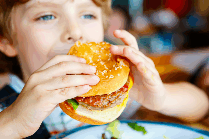 Little boy eating a burger