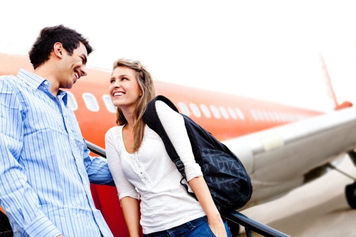 happy loving couple traveling by airplane and smiling
