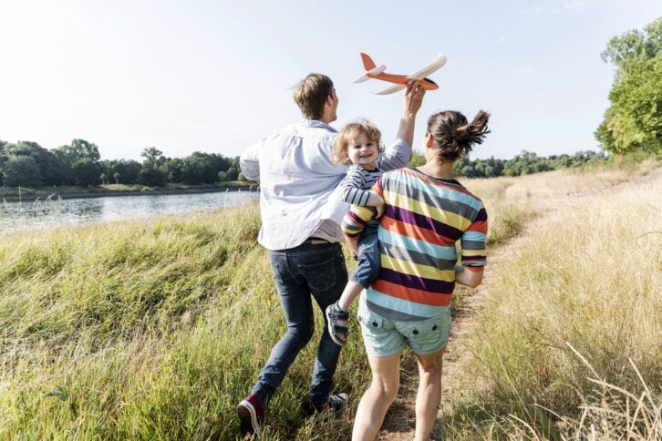 happy family walking at the riverside on a beautiful summer day