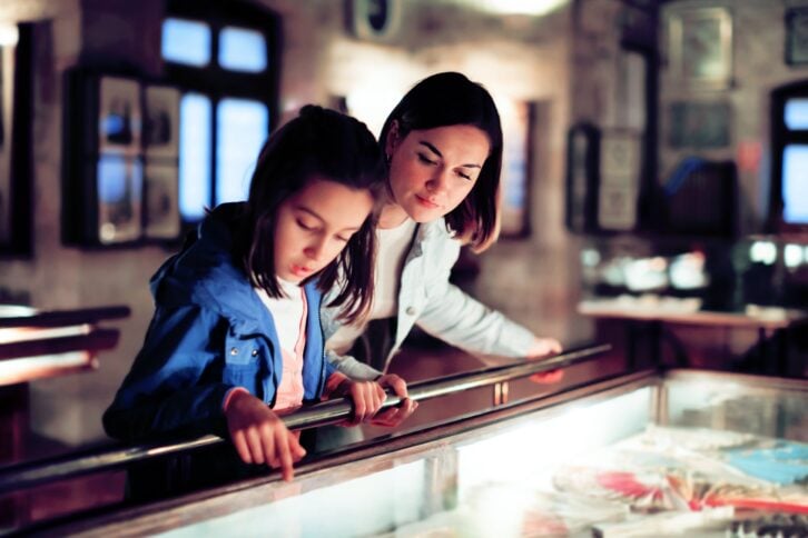 mother and daughter exploring expositions of previous centuries in museum