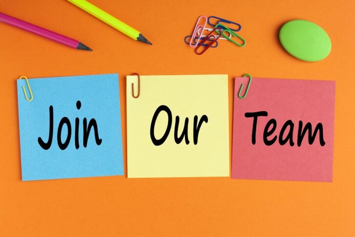 'Join Our Team' on post-it notes, laid on a bright orange table