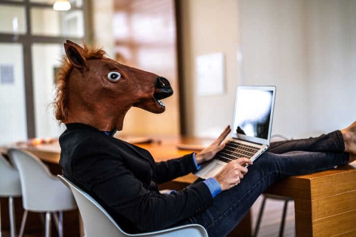 business man with horse mask working at office