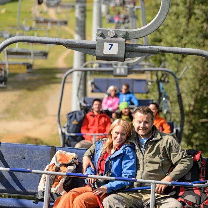 couple hugging on romantic chairlift trip sunny day