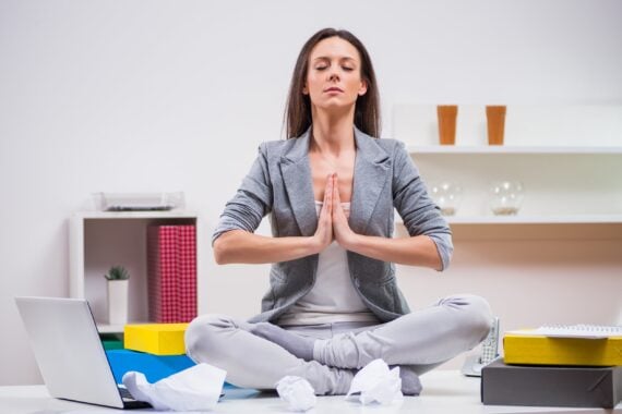 young businesswoman is meditating in her office