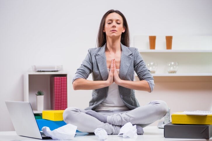 young businesswoman is meditating in her office