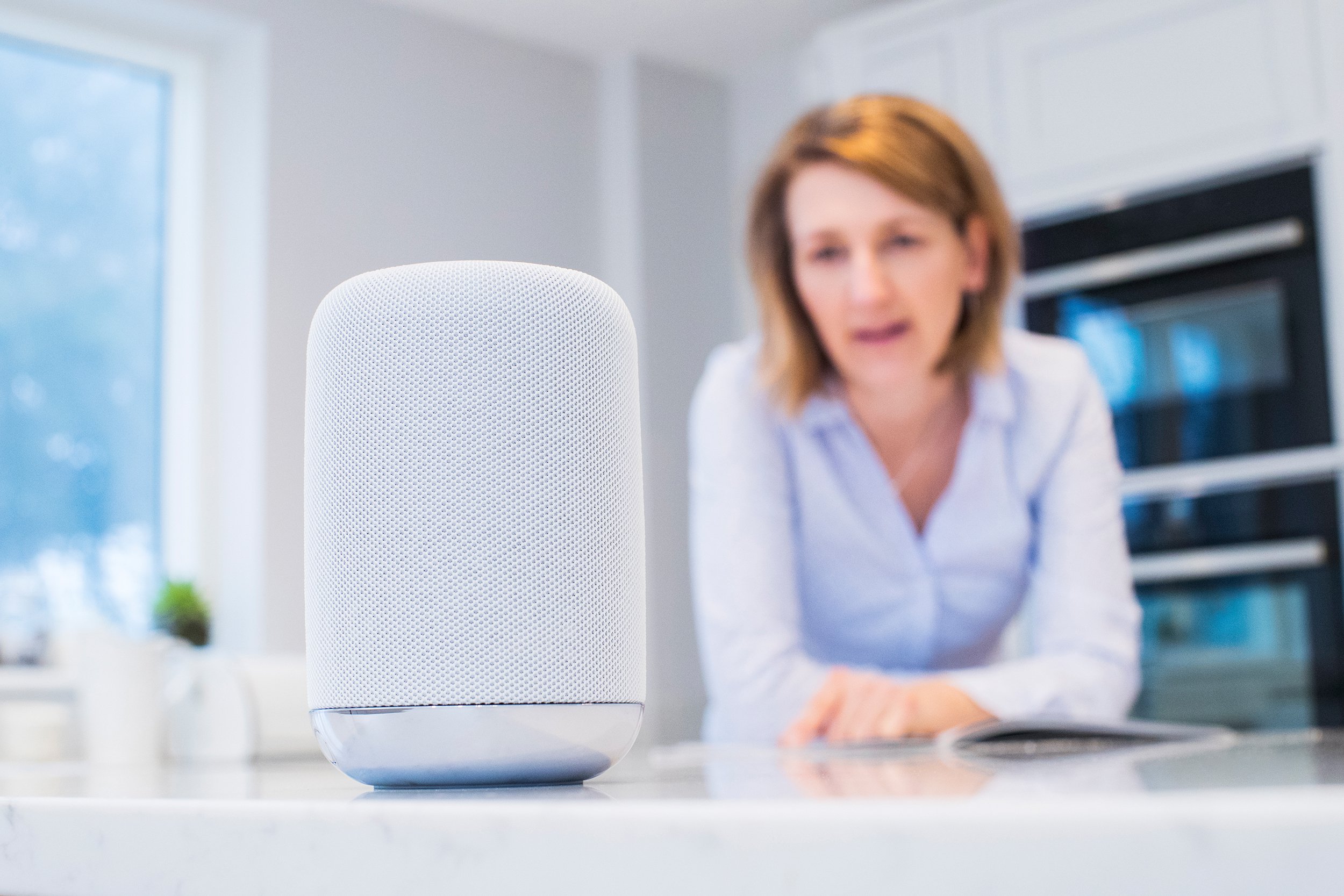 woman in kitchen asking digital assistant question