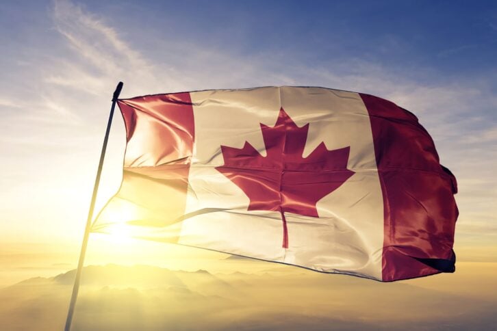 Canadian flag textile cloth fabric waving on the top sunrise mist fog
